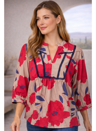 Model wearing Velvet Heart Zyler Shirt with red floral print and contrast trim, styled with blue jeans