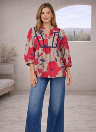 Model wearing Velvet Heart Zyler Shirt with red floral print and contrast trim, styled with blue jeans