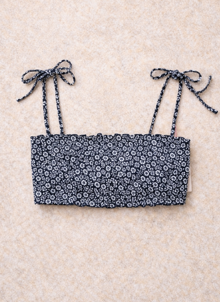 Ralph Lauren Smocked swim top with a navy ground, white floral design on a neutral color background. 