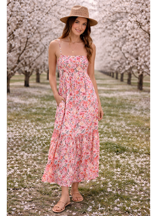 Woman in a floral dress and hat standing in an almond blossom field.  Saltwater Luxe Esme Maxi Floral Dress in pink floral print front view