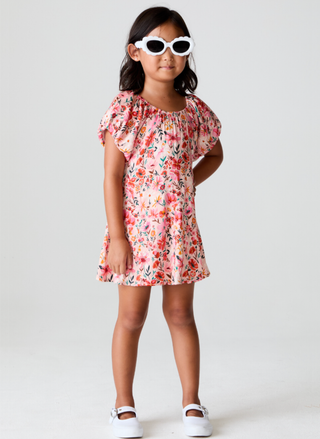 Young girl wearing a floral dress and sunglasses on a white background