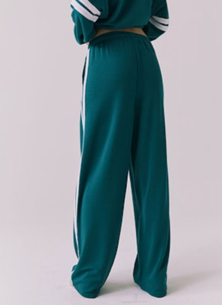 Teal tracksuit with white stripes on a light gray background