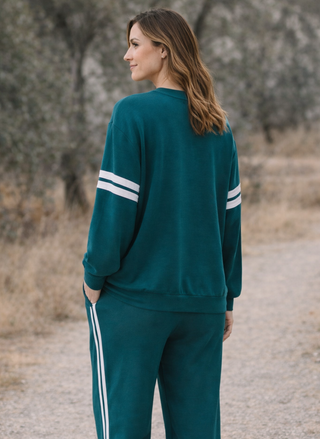 Back view of teal Chaser Cornell sweatshirt with relaxed drape and varsity stripe sleeves
