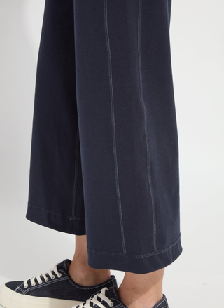 Navy blue pants worn by a person on a white background