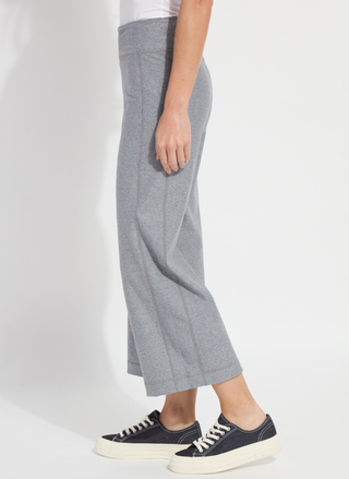 Person wearing gray checkered pants and black sneakers on a white background