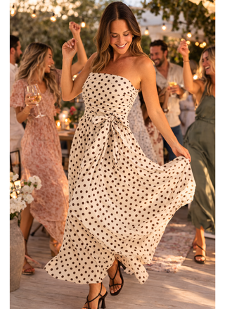 Woman in Brave & True Avalon polka dot dress dancing at an outdoor event with friends.
