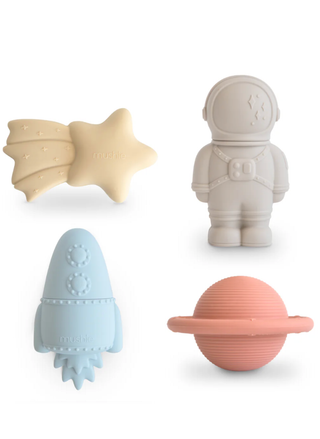 A 4-pack of Mushie silicone bath toys featuring a yellow shooting star, grey astronaut, blue rocket, and peach planet on a white background.
