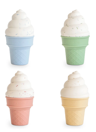 our Mushie silicone ice cream cones in blue, green, pink, and yellow with speckled white "frosting" tops on a clean white background.