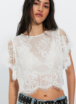 Model wearing Free People Lunar Ash Lace Top in white with denim found at August Boutique.