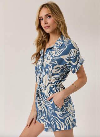 Woman wearing a blue and white patterned dress on a plain background