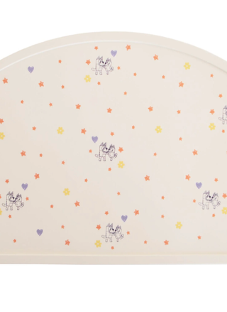 A semi-circle Mushie x Bluey silicone placemat in a soft cream color featuring Bluey and Bingo character art, stars, and hearts.