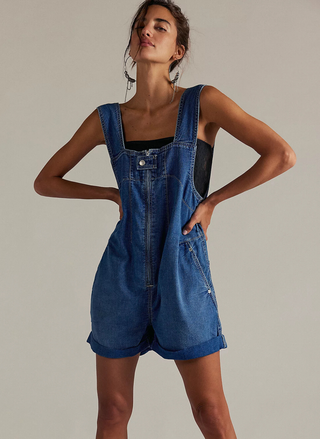 Front view of model wearing Free People Jude Denim Shortall in medium wash with front zip detail.