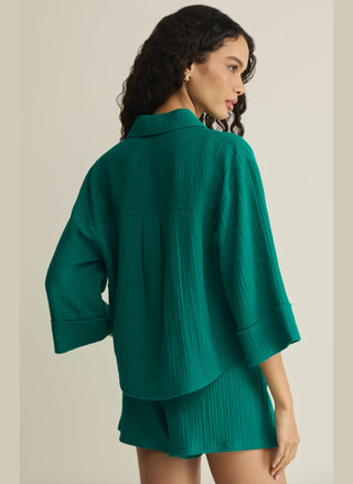 Woman wearing a green textured outfit on a beige background