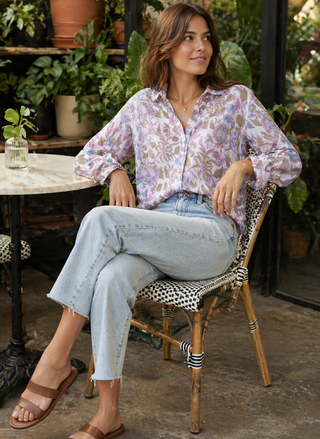Front view of model wearing Dylan Romy geometric print cotton long-sleeve shirt and dark-wash denim sitting at a cafe.