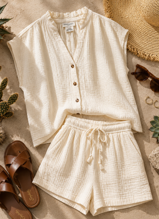Lifestyle flat lay of the Wesra Top paired with the matching Wasabi Short, a straw hat, and leather slides.