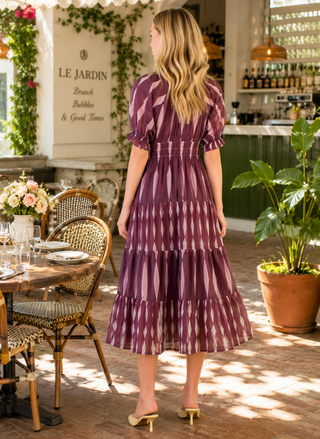 Back view of the tiered maxi dress showing the elegant drape and consistent geometric print.