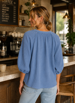 Back view of model wearing the blue Dylan Sun Washed Cotton Gauze Top with raw-edge neckline.