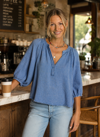 Front view of model wearing the blue Dylan Sun Washed Cotton Gauze Top with raw-edge V-neck.