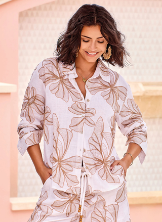 Front close-up view of a model wearing the white TRIBAL Oasis Long Sleeve Button Front Shirt highlighting the sand-colored floral embroidery.