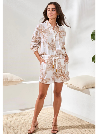 Woman wearing a floral outfit in a minimal indoor setting