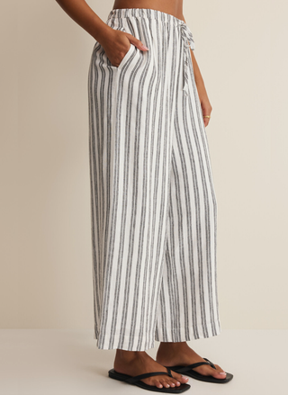 Side view of a model with her hand in the pocket of the Z Supply vertical stripe wide-leg ankle pants.