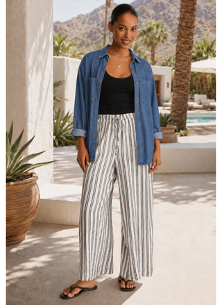 Front view of a model styling the Z Supply The Perfect Striped Pant with the adjustable drawcord waistband and black flat sandals.