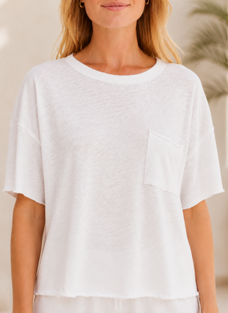 Front view close-up of a model styling the white Z Supply Everyday Boxy Pocket Tee, featuring the classic crew neck, relaxed short sleeves, and left chest pocket with raw edge details.
