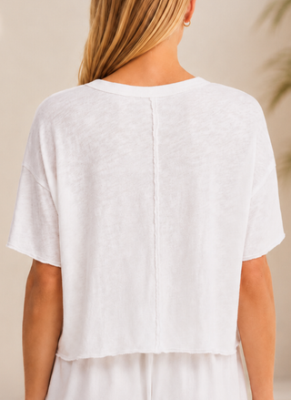 Back view of a model wearing the white Z Supply Everyday Boxy Pocket Tee, highlighting the relaxed fit, raw edge finishing, and exposed center back seam.