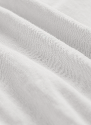 Close-up detail of the lightweight, white premium brushed slub jersey cotton fabric showcasing its soft, textured knit definition