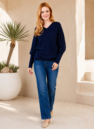Woman wearing Suzy D London Navy Lenny Long Sleeve Double V Neck Sweater with denim.
