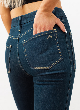 Back view of Wanderer Flare rinse jeans with classic back pockets and clean full-length hem, dark indigo denim.