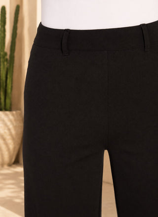 Close-up of women’s black high-waisted wide-leg pants showing the smooth pull-on waistband, belt loops, and tailored front seam detail.
