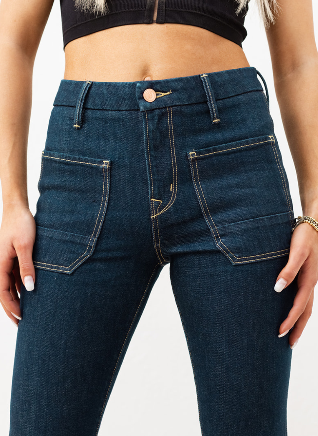The Wanderer Flare in dark rinse wash with front patch pockets, contrast stitching, and waist-defining rise—women’s flare jeans.