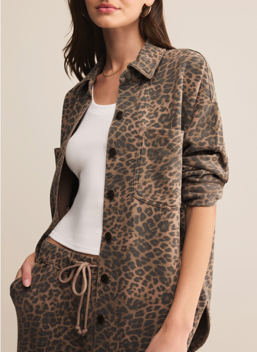 Person wearing a leopard print shirt and pants with a plain background