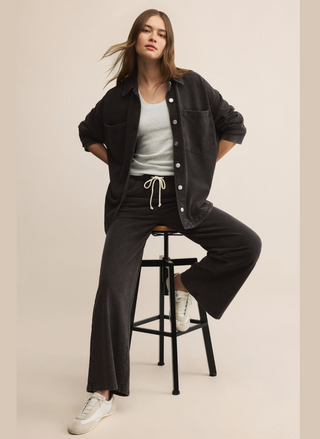 Woman wearing Z Supply Hunter Sweatpant in washed black with wide-leg fit and drawstring waist, styled with matching All Day Knit Jacket and sneakers.