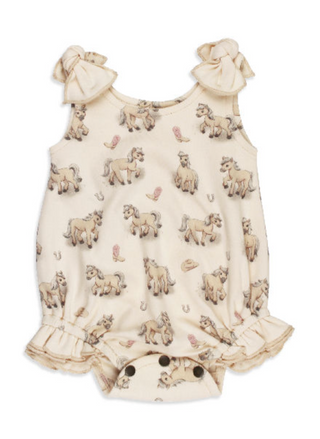 A cream-colored organic baby bodysuit by L'ovedbaby featuring a pattern of horses and blush pink cowboy boots with bow tie shoulder straps.
