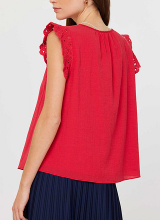 Front and back views of the Current Air Fire Fly Top: a ruby red cotton gauze blouse with scalloped crochet flutter sleeves, keyhole button closure at the round neckline, and soft gathers at the yoke, modeled with a pleated navy skirt.