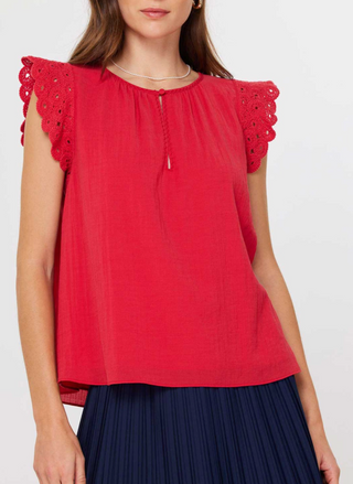 Front and back views of the Current Air Fire Fly Top: a ruby red cotton gauze blouse with scalloped crochet flutter sleeves, keyhole button closure at the round neckline, and soft gathers at the yoke, modeled with a pleated navy skirt.