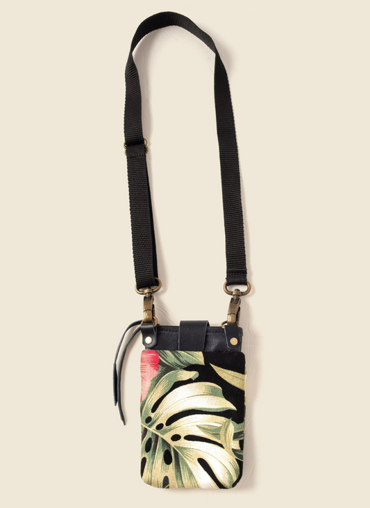 Upcycled tropical canvas and leather crossbody bag with adjustable black strap, brass hardware, and secure zipper closure. Ethically made by Casupo in Los Angeles.