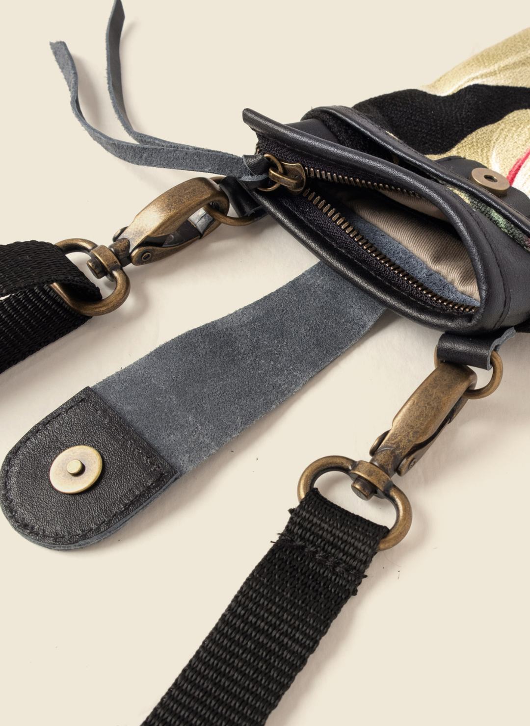 Upcycled tropical canvas and leather crossbody bag with adjustable black strap, brass hardware, and secure zipper closure. Ethically made by Casupo in Los Angeles.