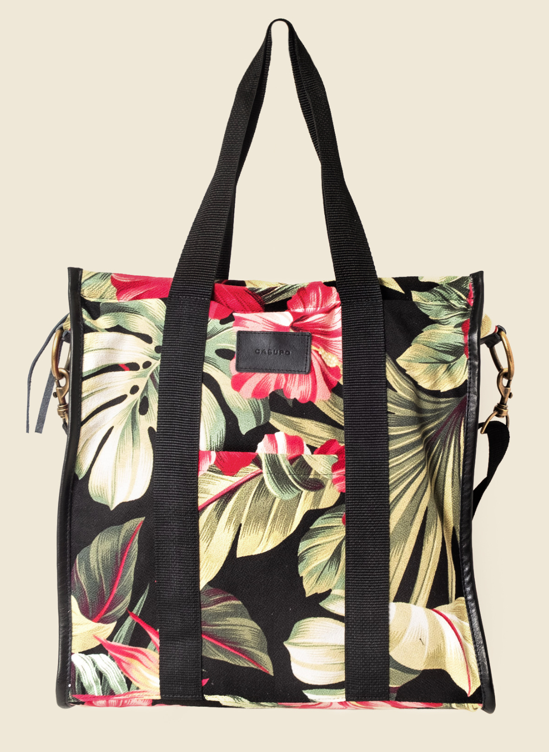 Casupo upcycled canvas and leather tote bag in tropical hibiscus print with interior zip pocket, black straps, and gold-tone hardware; handcrafted in Los Angeles.