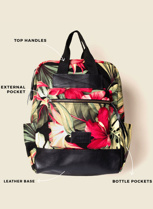 Casupo upcycled tropical hibiscus backpack with black leather base, top handles, bottle pockets, laptop sleeve, and suitcase strap; ethically made in Los Angeles.