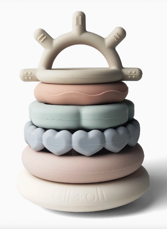 Stack of colorful silicone teething rings on a white background