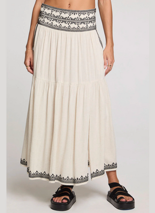 Long white skirt with black embroidery on a plain background