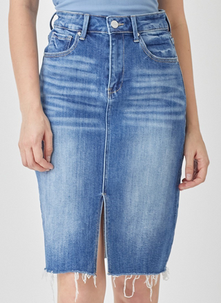 Blue denim skirt worn by a person on a plain background