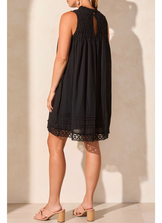 Black dress with lace details worn by a person against a neutral background