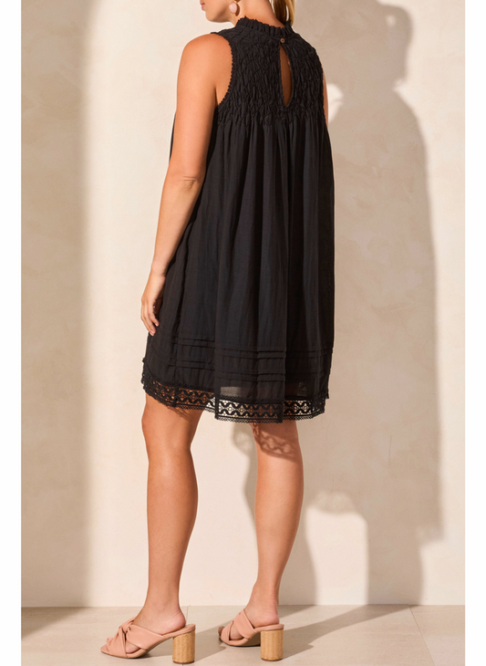 Black dress with lace details worn by a person against a neutral background