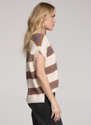 Side view of the Saltwater Luxe Fitz Sweater Top in cream with camel and ocean-blue horizontal stripes, sleeveless V-neck ribbed knit with relaxed boxy fit, styled with black denim jeans for a casual chic look.