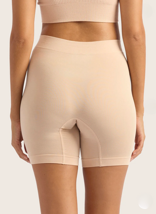 Beige shapewear shorts worn by a person on a plain background