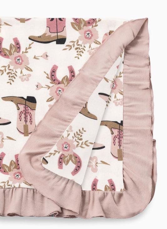 western inspired blanket for baby.  Horseshoes, boots, flower print with a pink ruffle.
